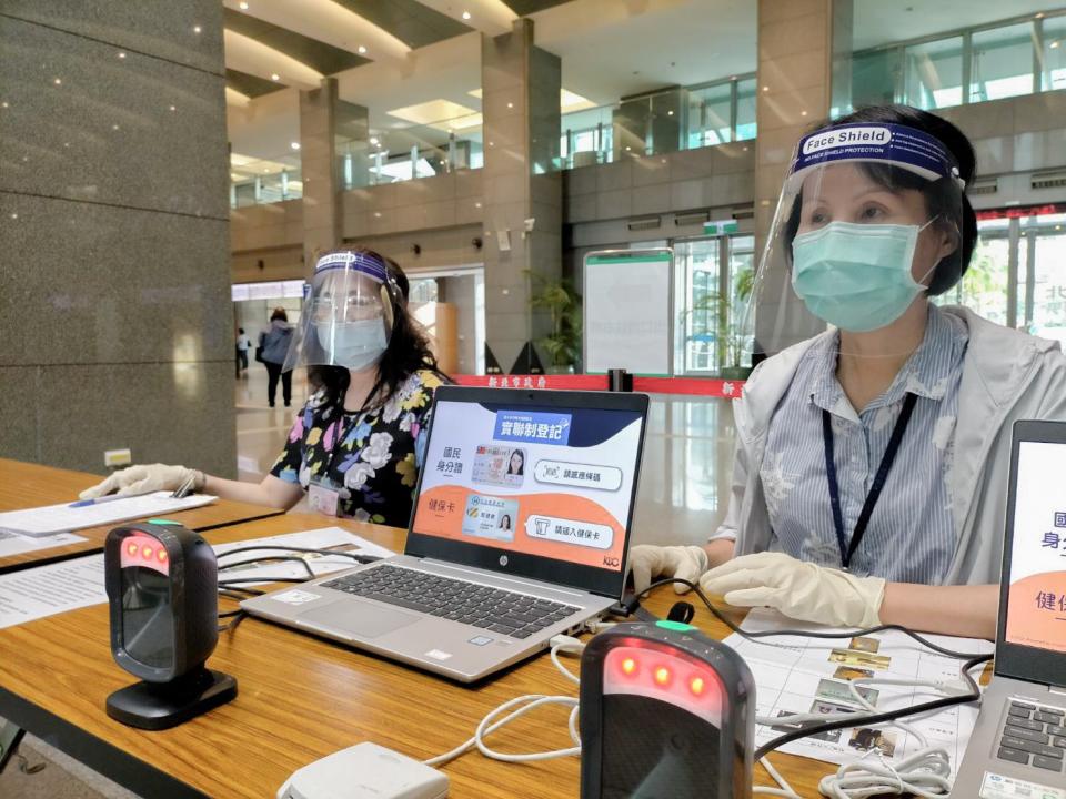 疫情持續嚴峻，一線人員配戴防護面罩服務民眾。   圖：新北市政府地政局/提供