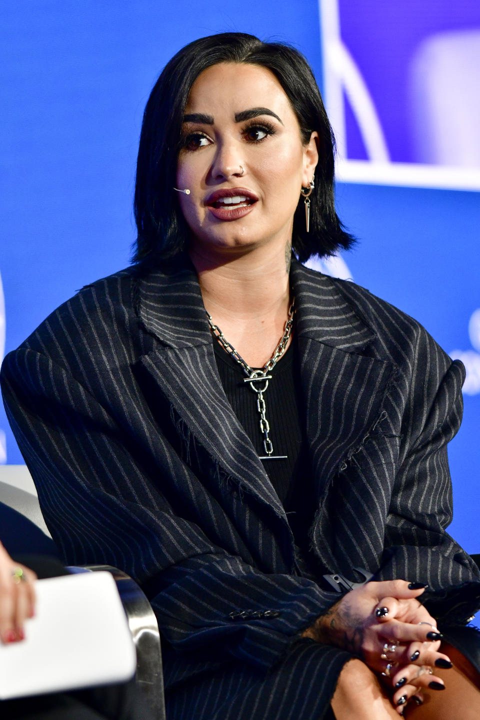 Close-up of Demi seated onstage