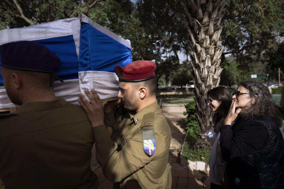 The mother and sister of Israeli soldier Lt. Yaacov Elian, follow his flag-draped casket during his funeral at Kiryat Shaul military cemetery in Tel Aviv, Israel, Friday, Dec. 22, 2023. Elian, 20, was killed during Israel's ground operation in the Gaza Strip, where the Israeli army has been battling Palestinian militants in the war ignited by Hamas' Oct. 7 attack into Israel. (AP Photo/Oded Balilty)