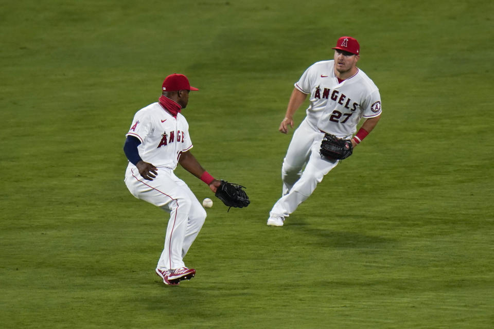 Los Angeles Angels' Mike Trout, right, watches as Justin Upton makes a fielding error while trying to catch a ball hit by Oakland Athletics' Mark Canha during the fourth inning of a baseball game, Monday, Aug. 10, 2020, in Anaheim, Calif. (AP Photo/Jae C. Hong)