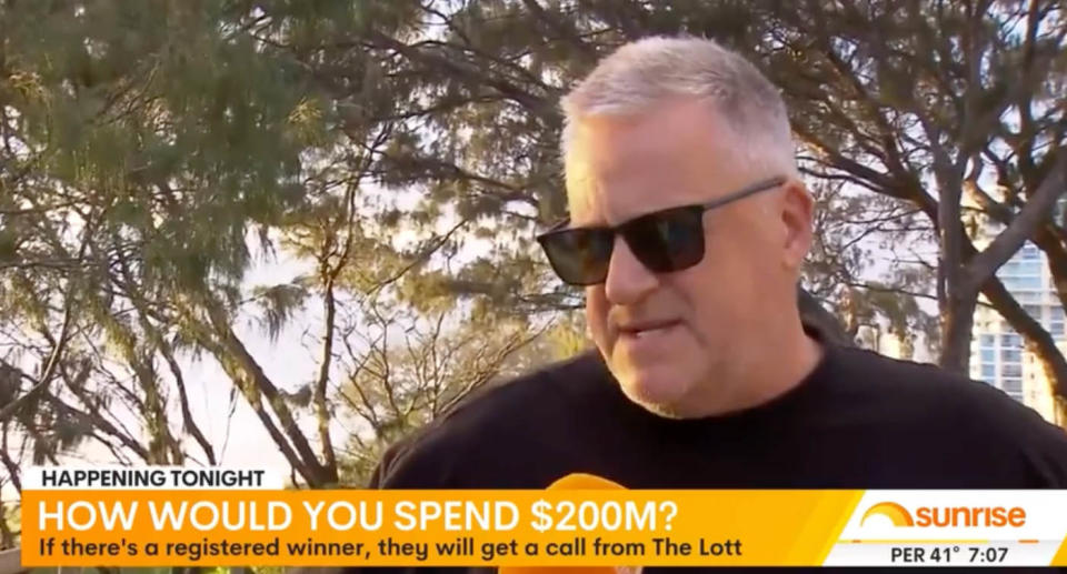 The man appears on Sunrise wearing a black T-shirt and glasses.