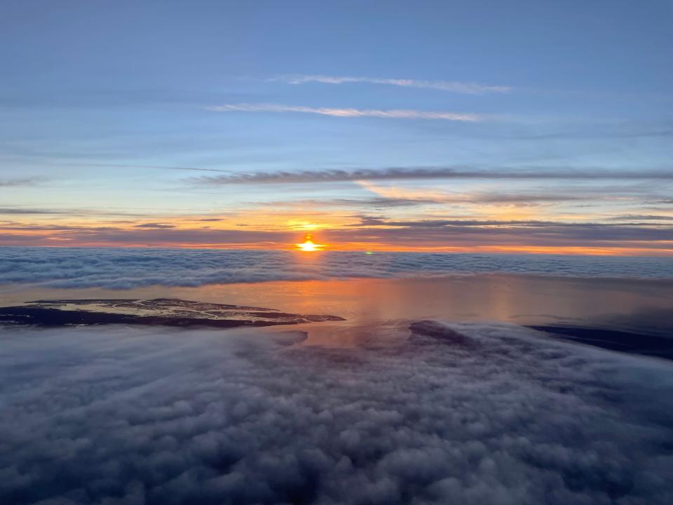 View from a plane of a sunrise and clouds.