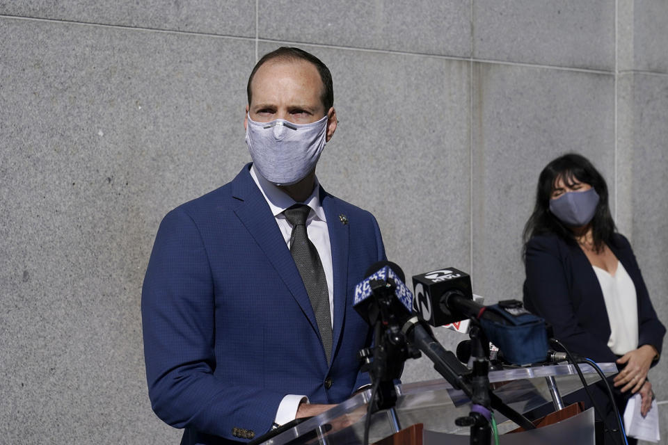 Former San Francisco district attorney Chesa Boudin speaks next to then–director of communications and policy adviser Rachel Marshall at a news conference in San Francisco on Nov. 23, 2020.