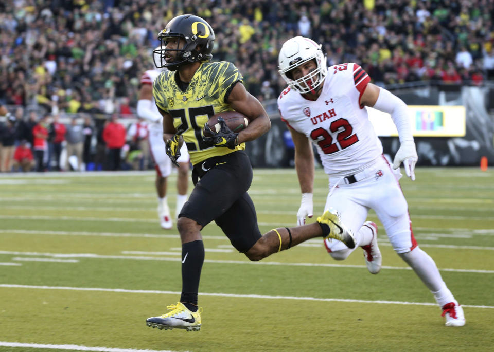 Oregon running back Tony Brooks-James, left, scores a touchdown ahead of Utah’s Chase Hansen during the fourth quarter of an NCAA college football game Saturday, Oct. 28, 2017, in Eugene, Ore. (AP Photo/Chris Pietsch)