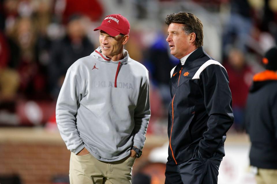 Oklahoma coach Brent Venables, left, and Oklahoma State coach Mike Gundy before a Bedlam college football game between  the University of Oklahoma Sooners (OU) and the Oklahoma State University Cowboys (OSU) at Gaylord Family-Oklahoma Memorial Stadium in Norman, Okla., Saturday, Nov. 19, 2022.