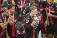 Leverkusen's Florian Wirtz kisses the trophy as his team won the German Bundesliga, after the German Bundesliga soccer match between Bayer Leverkusen and FC Augsburg at the BayArena in Leverkusen, Germany, Saturday, May 18, 2024. Bayer Leverkusen have won the Bundesliga title for the first time. It is the first team in Bundesliga history, that won the championship unbeaten for the whole season. (AP Photo/Michael Probst)