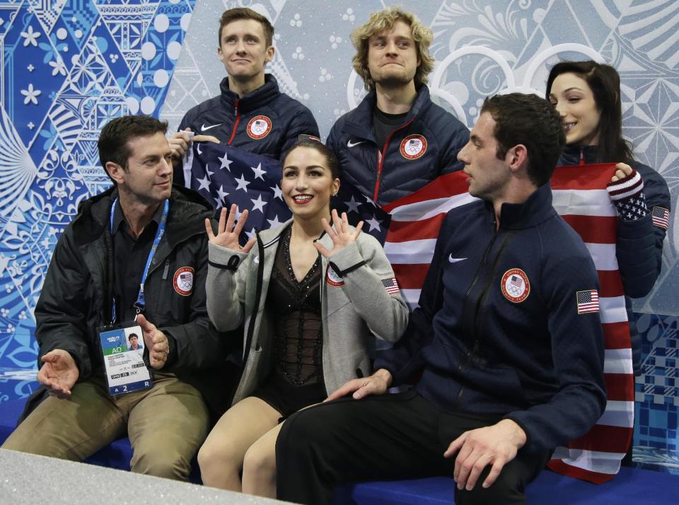 Marissa Castelli, centre, and Simon Shnapir of the United States, right, wait for their results following the team pairs short program figure skating competition at the Iceberg Skating Palace during the 2014 Winter Olympics, Thursday, Feb. 6, 2014, in Sochi, Russia. (AP Photo/Darron Cummings, Pool)