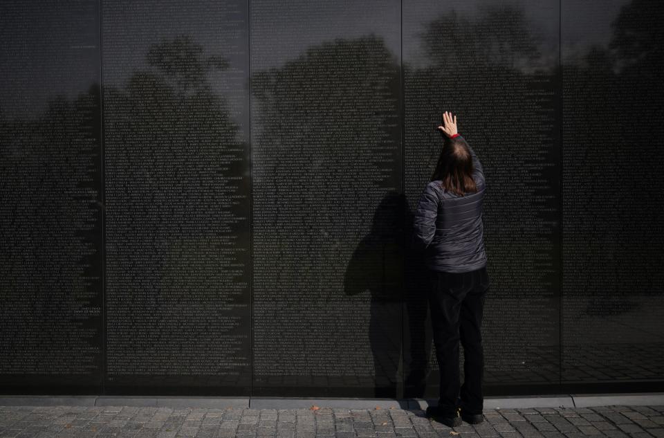 A woman places her hand on the Vietnam War Memorial on Veterans Day on Nov. 11, 2019 in Washington, DC. (Photo: Mandel Ngan/AFP via Getty Images)
