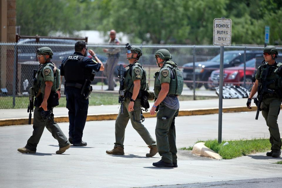 Law enforcement personnel stand outside Robb Elementary School following a shooting, Tuesday, May 24, 2022, in Uvalde, Texas.