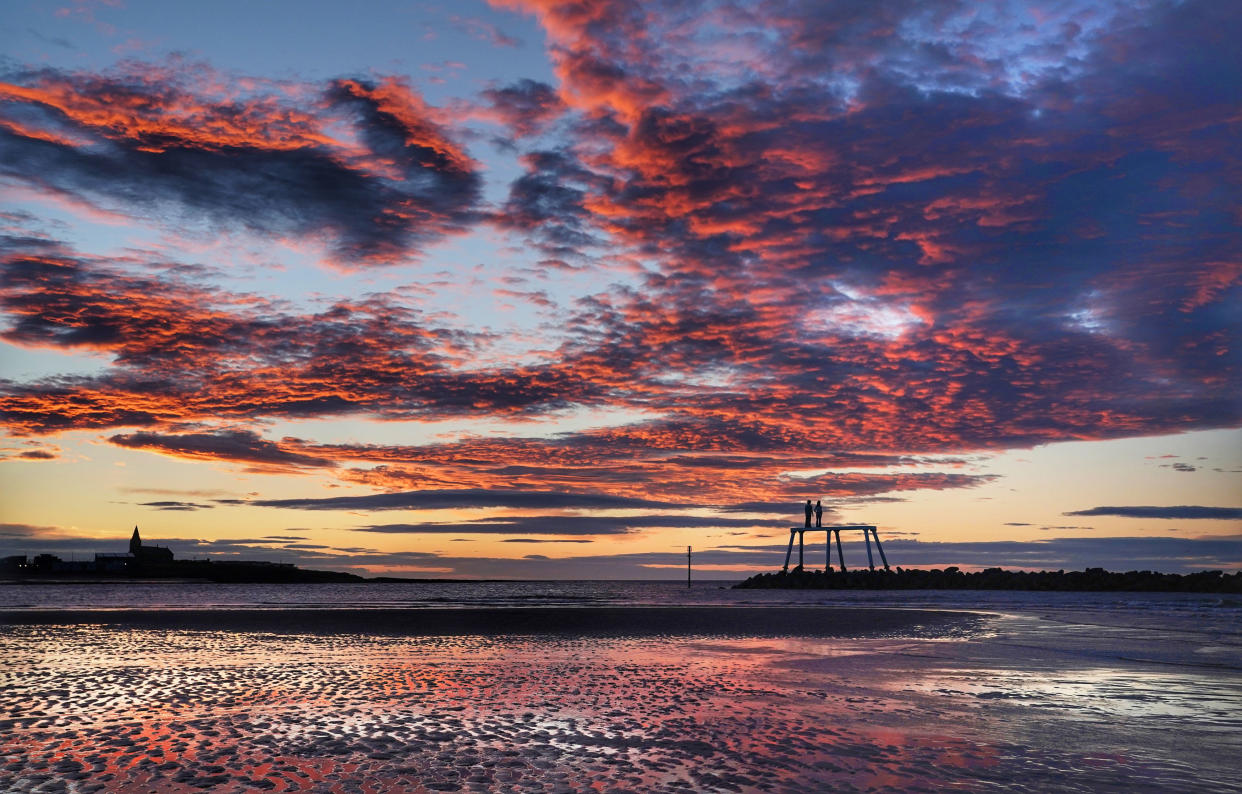 An orange sky just before sunrise in Newbiggen-by-the-Sea in Northumberland on Tuesday (PA)