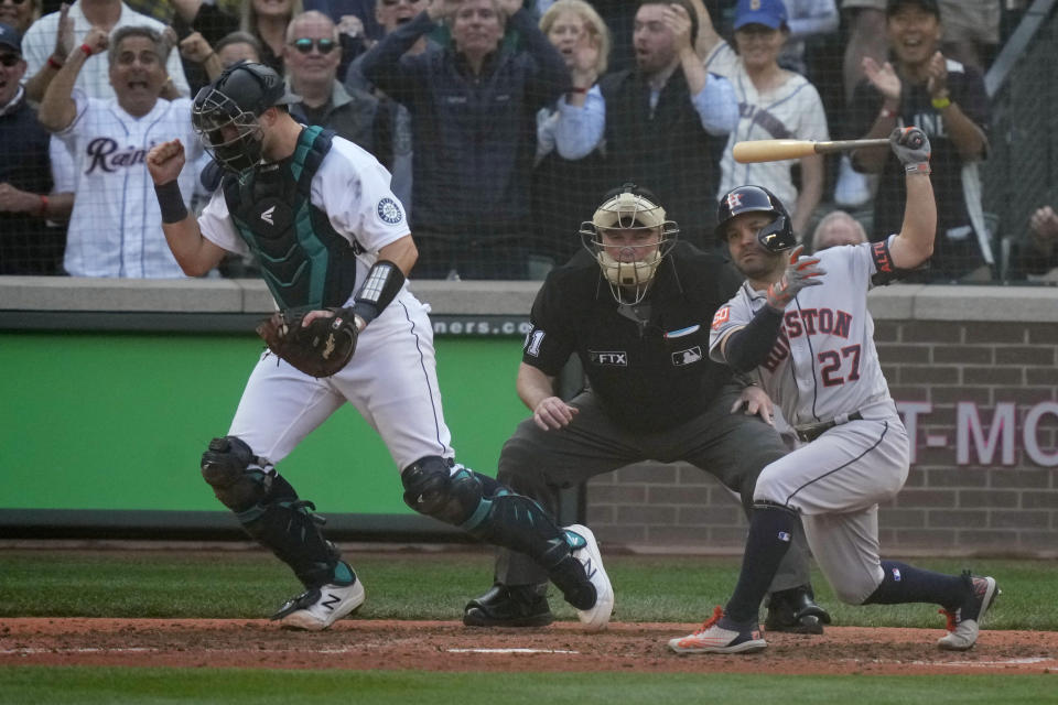 Seattle Mariners catcher Cal Raleigh, left, reacts after Houston Astros' Jose Altuve (27) struck out during the ninth inning in Game 3 of an American League Division Series baseball game Saturday, Oct. 15, 2022, in Seattle. (AP Photo/Stephen Brashear)