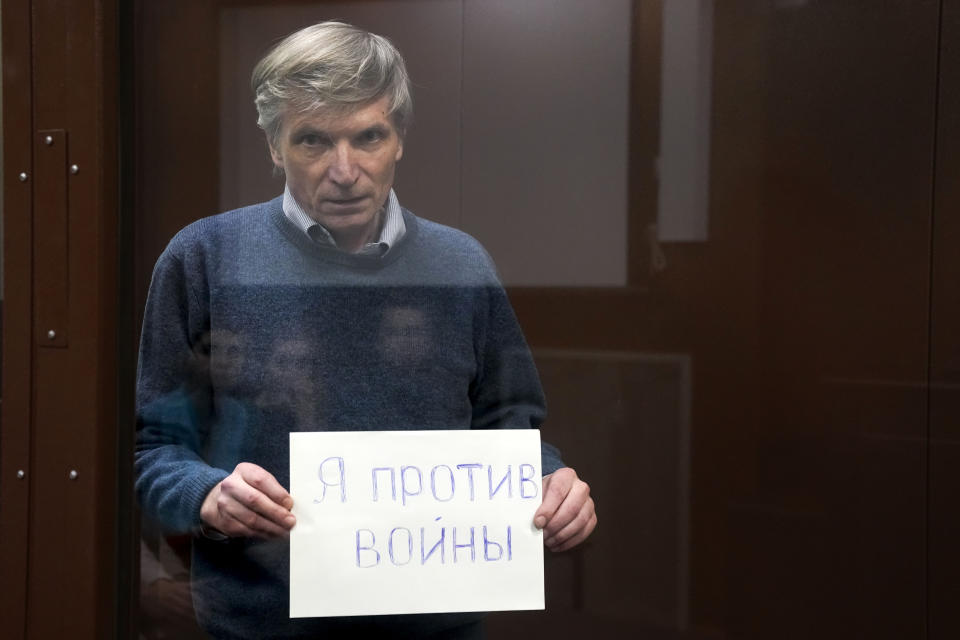 FILE - Alexei Gorinov holds a sign "I am against the war" standing in a cage during hearing in the courtroom in Moscow, Russia, on June 21, 2022. Gorinov, a former member of a Moscow municipal council, was convicted of "spreading false information" about the army in July over antiwar remarks he made at a council session. Criticism of the invasion was criminalized a few months earlier, and Gorinov, 61, became the first Russian sent to prison for it, receiving seven years. (AP Photo, File)