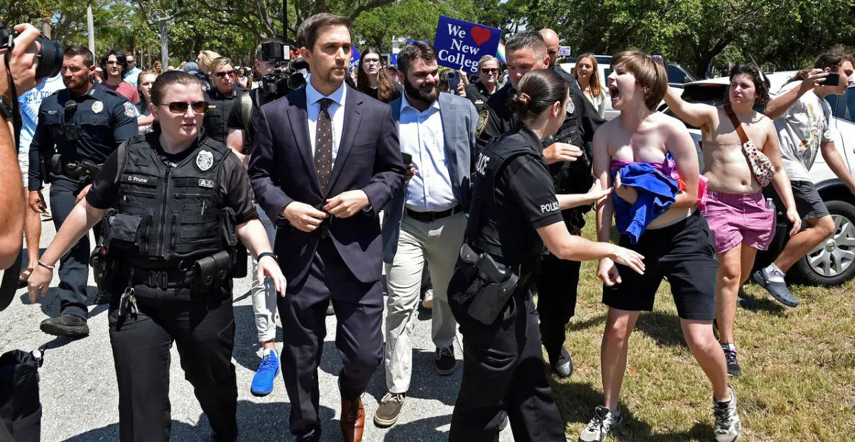 Christopher Rufo, center, a member of the New College board of trustees, is surrounded by student protesters May 15 after leaving a bill signing ceremony that Gov. Ron DeSantis held on campus.