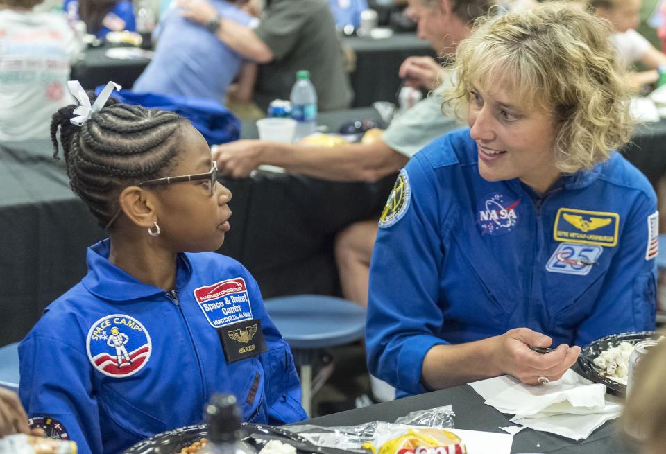 FILE - NASA astronaut Dottie Metcalf-Lindenburger talks with Space Camp camper Bria Jackson, of Atlanta, before giving a speech at the U.S. Space & Rocket Center in Huntsville, Ala. in this July 13, 2018 file photo. Space Camp, an educational program attended by nearly 1 million people, said Tuesday, July 28, 2020 it's in danger of closing without a cash infusion because of the coronavirus pandemic. (AP Photo/Vasha Hunt, File)