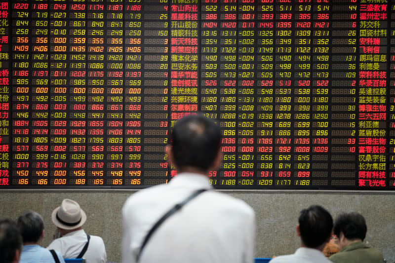 FILE PHOTO: People look at an electronic board showing stock information at a brokerage house in Shanghai, China July 6, 2018. REUTERS/Aly Song