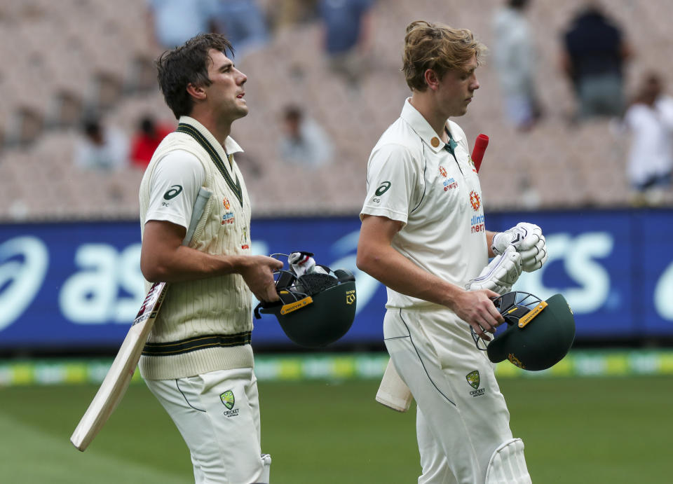 Australian not out batsmen Pat Cummins, left, and teammate Cameron Green walk from the field at the close of play on day three of the second cricket test between India and Australia at the Melbourne Cricket Ground, Melbourne, Australia, Monday, Dec. 28, 2020. (AP Photo/Asanka Brendon Ratnayake)