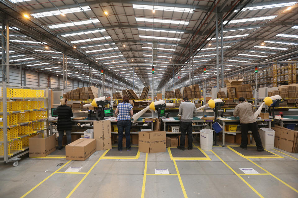 PETERBOROUGH, ENGLAND - NOVEMBER 28:  Employees pack items before dispatching them in the huge Amazon 'fulfilment centre' warehouse on November 28, 2013 in Peterborough, England. The online retailer is preparing for 'Cyber Monday', as it predicts that the busiest day for online shopping in the UK will fall on Monday December 2nd this year. On Cyber Monday in 2012 amazon.co.uk recorded over 3.5 million individual items ordered, which equates to 41 items purchased per second. The Peterborough fulfilment centre is 500,000 sq ft, equivalent to approximately seven football pitches in floor area. Amazon are due to employ more than 1,000 seasonal staff to cope with increased demand in the run up to Christmas.  (Photo by Oli Scarff/Getty Images)