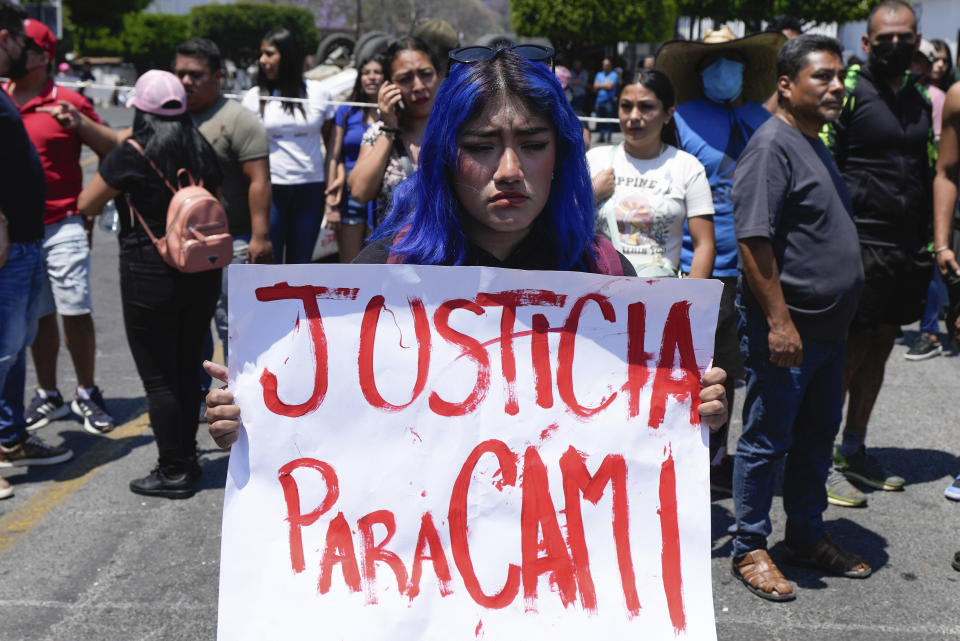 A woman holds a sign with a message that reads in Spanish: "Justice for Cami" in reference to an 8-year-old girl who disappeared the previous day, in Taxco, Mexico, Thursday, March 28, 2024. The 8-year-old girl disappeared Wednesday; her body was found on a road on the outskirts of the city early Thursday. (AP Photo/Fernando Llano)