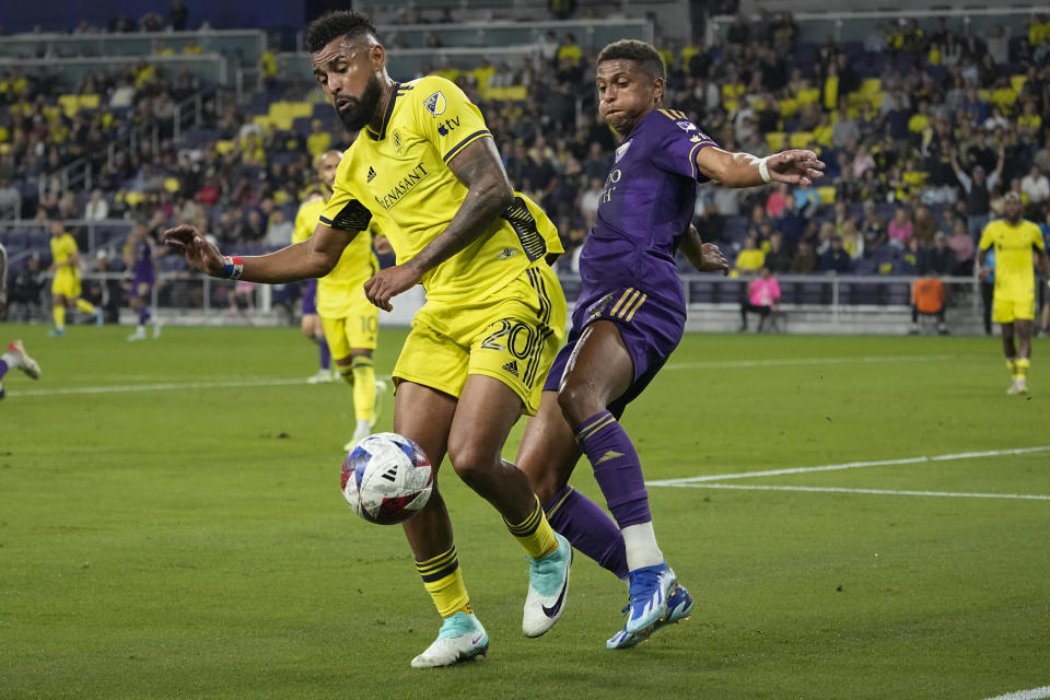 Nashville SC midfielder Anibal Godoy (20) takes the ball from Orlando City defender Rafael Santos, right, during the first half of an MLS playoff soccer match Tuesday, Nov. 7, 2023, in Nashville, Tenn. (AP Photo/George Walker IV)