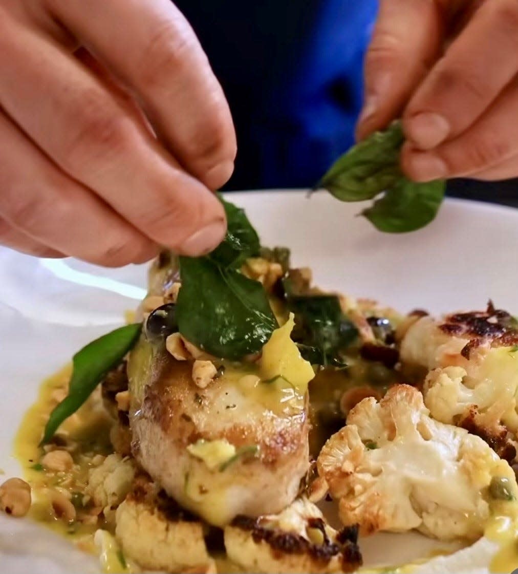 Atlantic halibut with roasted cauliflower, cauliflower and nori puree, topped with brown butter, hazelnuts, grapes and curry leaves served at Juniper Hill in the Annandale section of Clinton.