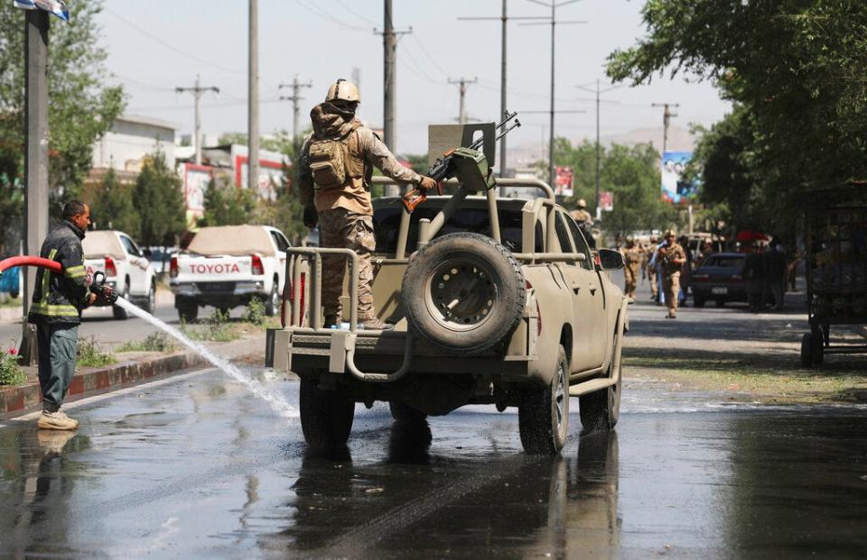 In this June 6, 2021, photo, Afghan security personnel leave the scene of a roadside bomb explosion in Kabul, Afghanistan. The U.S. withdrawal from Afghanistan is more than half done, and U.S. officials say that while it could be completed by July 4, the final exit of equipment and troops more likely will be later in the summer.