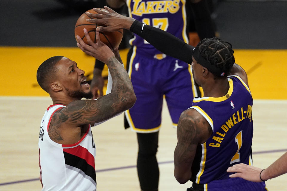 Los Angeles Lakers guard Kentavious Caldwell-Pope (1) blocks a shot by Portland Trail Blazers guard Damian Lillard (0) during the first half of an NBA basketball game Friday, Feb. 26, 2021, in Los Angeles. (AP Photo/Mark J. Terrill)