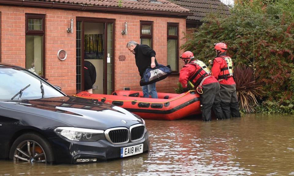 Members of the Fire and Rescue service helping a resident of Fishlake