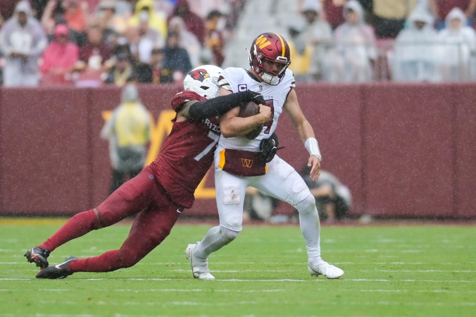 A player is tackled from behind by Arizona Cardinals linebacker Kyzir White (7) during the second half at FedExField on Sept. 10, 2023, in Landover, Maryland.