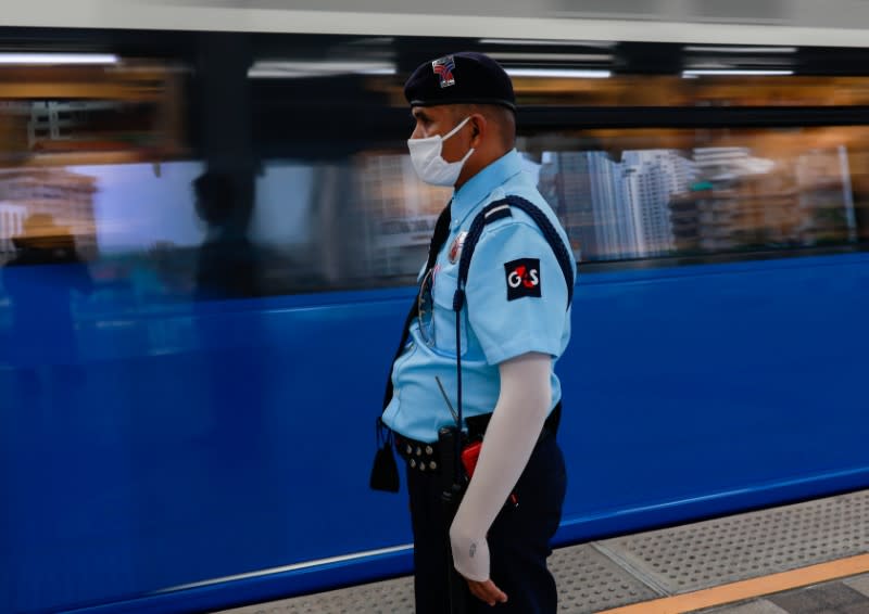 A security guard wears a protective face mask due to the coronavirus disease (COVID-19) outbreak, as he stands guard at a train station in central Bangkok