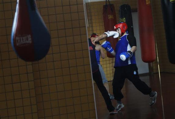 Argentine born boxer Tamara Fabiana Garcia gets punched in the face by fellow boxer Jennifer Miranda during a training session at a high-performance sports centre in Los Alcazares, southeastern Spain, April 2, 2012.