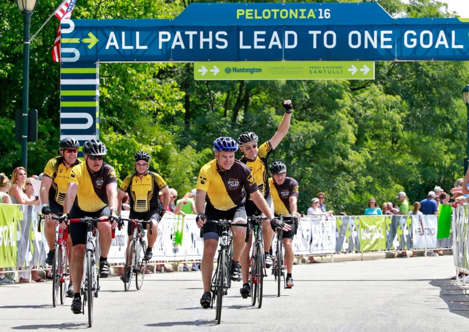 Pelotonia riders from Bo's Tire Barn cross the finish line in New Albany Market Square in 2016.