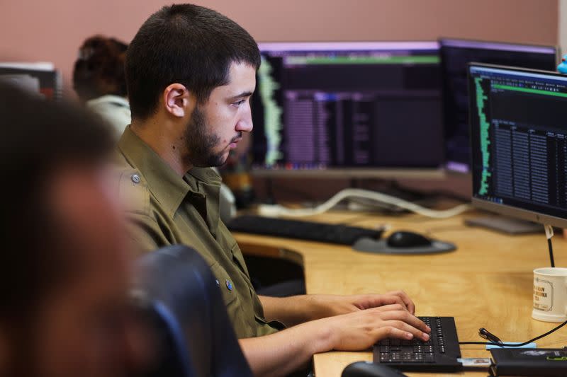 Technologists with the Israeli military's Matzpen operational data and applications unit work at their stations at an IDF base in Ramat Gan