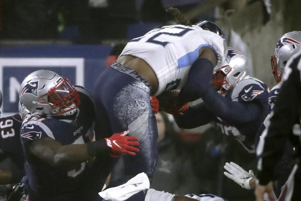 Tennessee Titans running back Derrick Henry goes over New England Patriots defenders for a touchdown in the first half of an NFL wild-card playoff football game, Saturday, Jan. 4, 2020, in Foxborough, Mass. (AP Photo/Elise Amendola)