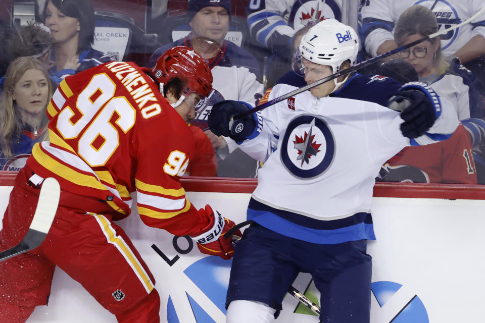 Winnipeg Jets' Vladislav Namestnikov (7) collides with Calgary Flames' Andrei Kuzmenko during the second period of an NHL hockey game in Calgary, Alberta, Monday, Feb. 19, 2024. (Larry MacDougal/The Canadian Press via AP)