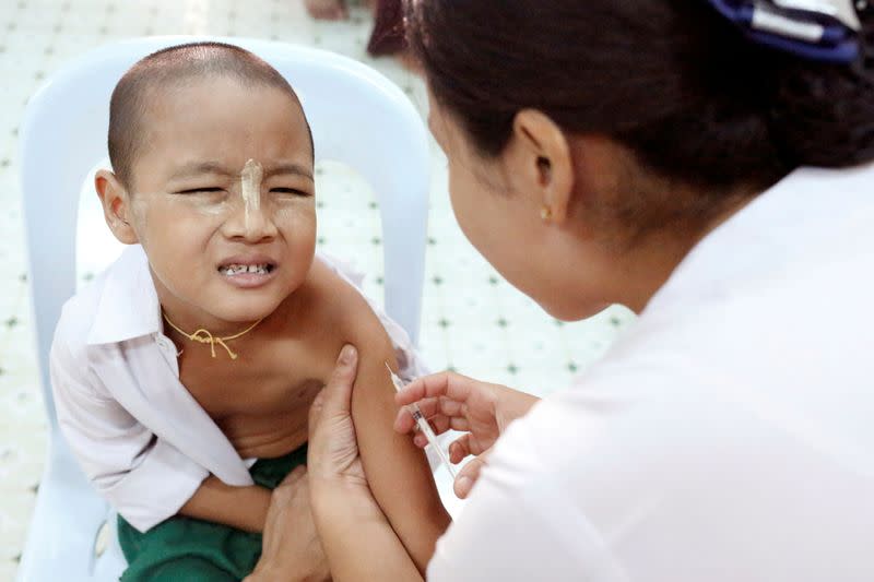 FILE PHOTO: A child reacts while receiving a measles-rubella vaccination in Yangon