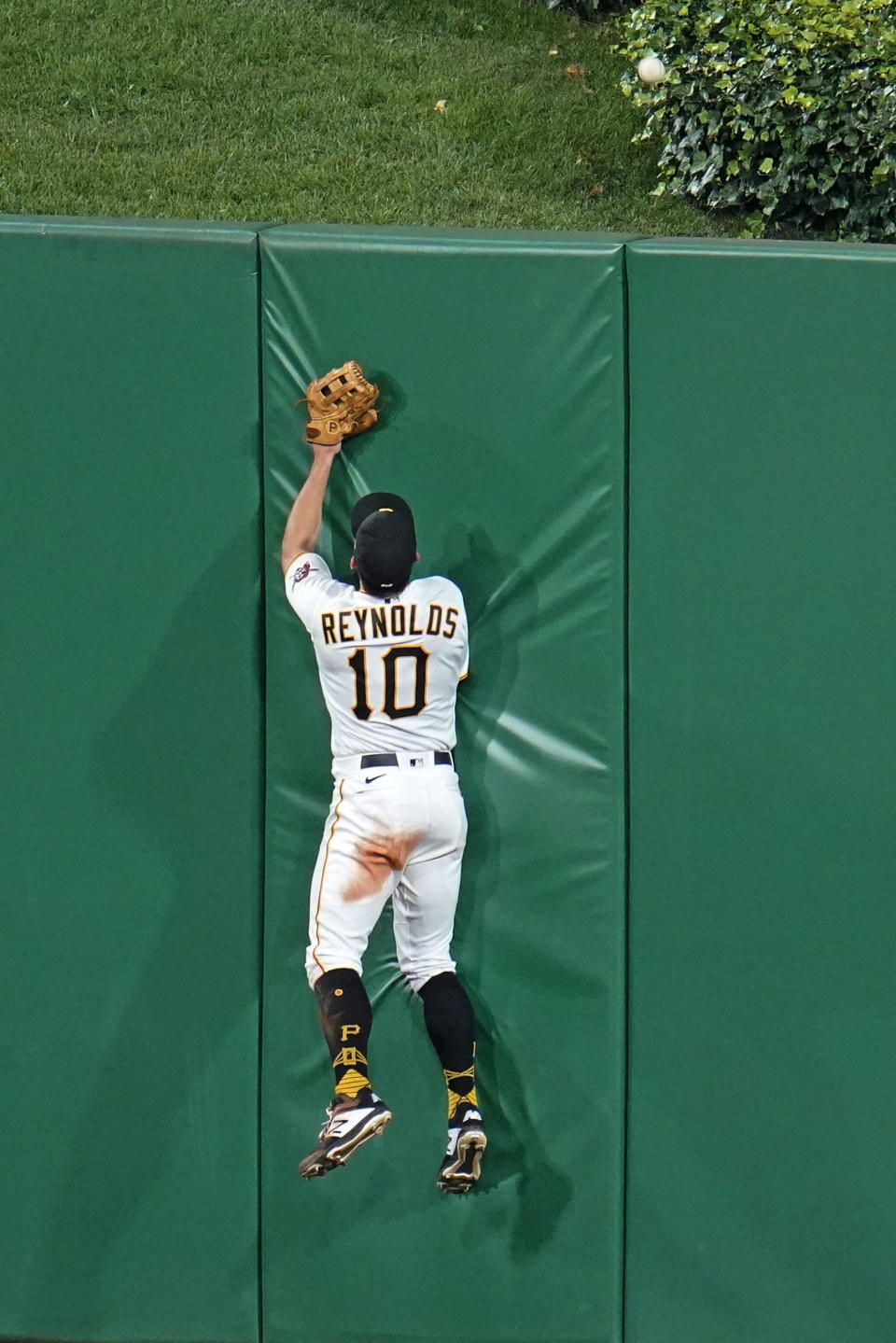 Pittsburgh Pirates center fielder Bryan Reynolds leaps against the center field wall on a a grand slam hit by Cleveland Indians' Cesar Hernandez during the seventh inning of a baseball game in Pittsburgh, Friday, June 18, 2021. (AP Photo/Gene J. Puskar)