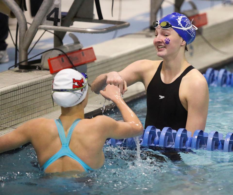 Brandywine's Rachel Bockrath (facing camera) shares a fist bump after Bockrath won the 50 yard freestyle race during the DIAA girls swimming state championships at Rawstrom Natatorium at the University of Delaware, Saturday, Feb. 25, 2023.