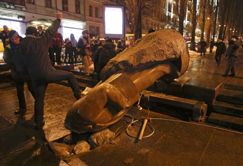 People surround a statue of Soviet state founder Vladimir Lenin, which was toppled by protesters during a rally organized by supporters of EU integration in Kiev, December 8, 2013. Crowds toppled a statue of Soviet state founder Vladimir Lenin in the Ukrainian capital and attacked it with hammers on Sunday in the latest mass protests against President Viktor Yanukovich and his plans for closer ties with Russia. REUTERS/Stoyan Nenov (UKRAINE - Tags: POLITICS CIVIL UNREST)