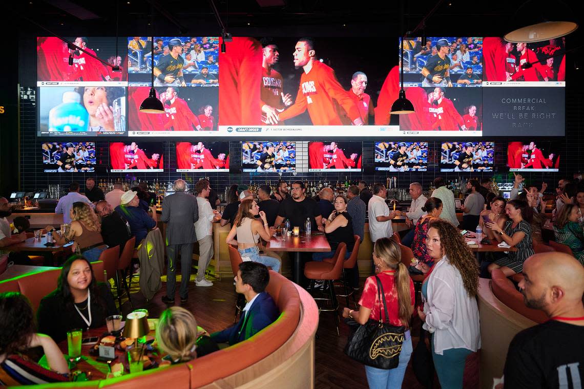 Patrons drink and dine at Sports & Social, a sports bar with live entertainment and arcade games, at Vivo! Dolphin Mall.
