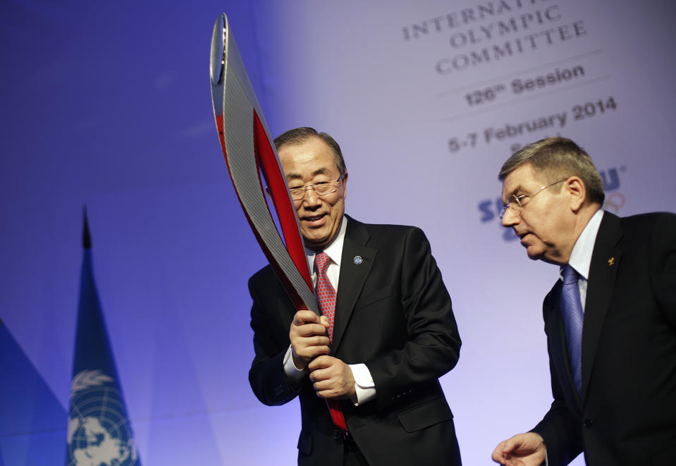 United Nations Secretary-General Ban Ki-moon, left, is handed an Olympic torch by International Olympic Committee President Thomas Bach after Ban addressed the IOC general assembly ahead of the upcoming 2014 Winter Olympics, Thursday, Feb. 6, 2014, in Sochi, Russia. It was the first time a U.N. secretary-general delivered a keynote address to the IOC's general assembly. (AP Photo/David Goldman)