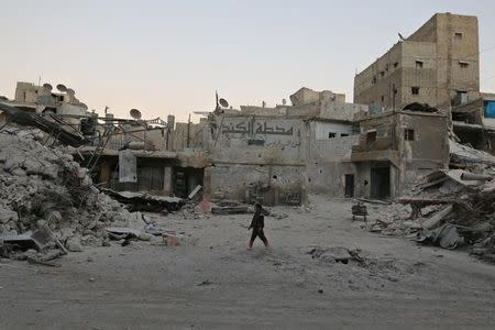 A boy walks amid damaged buildings in the rebel held area of al-Kalaseh neighborhood of Aleppo. REUTERS/Abdalrhman Ismail