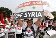 Syrian-American demonstrator Manar Kodamah leads a chant against possible U.S. military intervention in the conflict in Syria as a group of Syrian-Americans protest in front of the White House in Washington, September 9, 2013. REUTERS/Jim Bourg