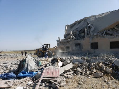 People inspect the site of Saudi-led air strikes on a Houthi detention centre in Dhamar