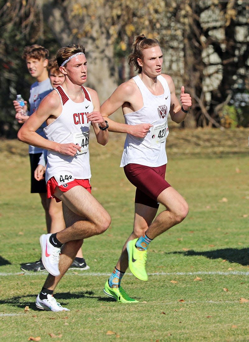 Iowa City, City High senior Ford Washburn (444) and Dowling Catholic West Des Moines senior Jackson Heidesch (427) run side by side during the State Cross Country Class 4A Boys 5K race at the Lakeside Municipal Golf Course in Fort Dodge.