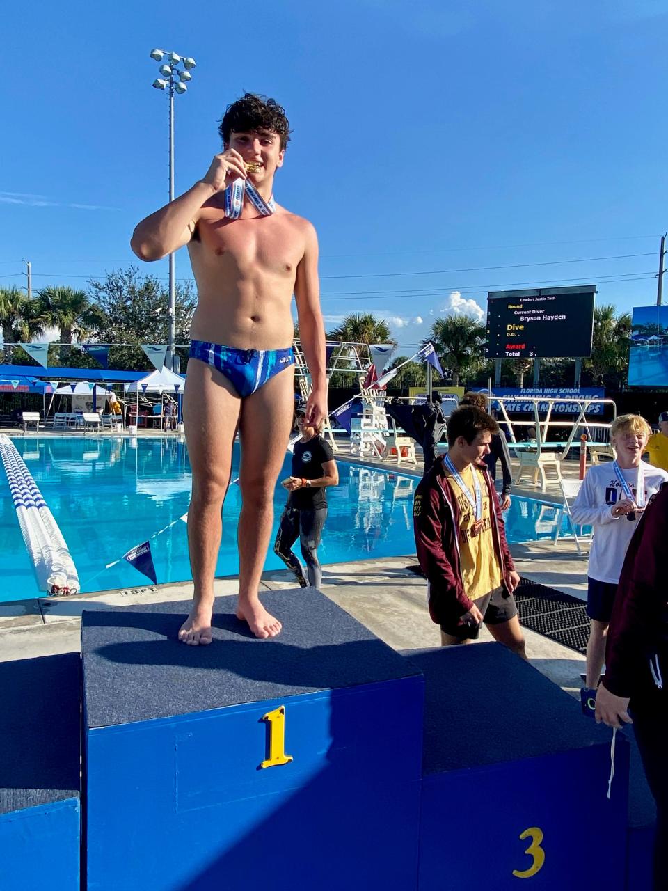 Booker T. Washington senior Justin Toth celebrates at the top of the podium after capturing the Class 3A state diving championship on Saturday, November 13, 2021 from the Sailfish Splash Waterpark and Aquatics Center in Stuart.