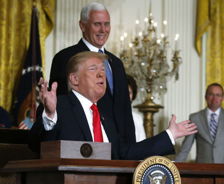 U.S. President Donald Trump reacts next to Vice President Mike Pence after signing a national space policy directive during a meeting of the National Space Council in the East Room of the White House in Washington, U.S., June 18, 2018. REUTERS/Leah Millis