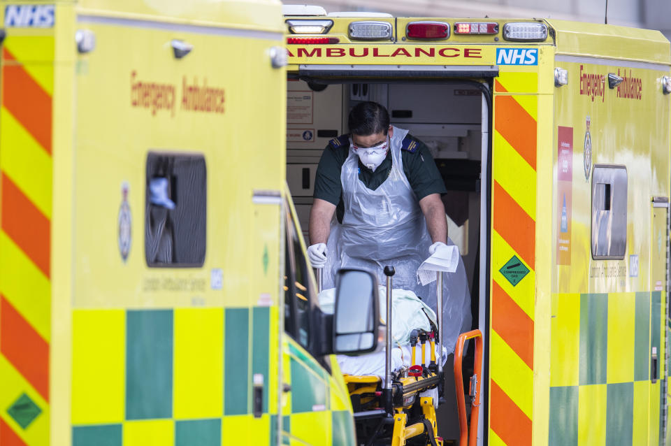 LONDON, UNITED KINGDOM - APRIL 20: A London Ambulance worker takes a patient with an unknown condition from an ambulance outside of the Royal London Hospital on April 20, 2020 in London, England. The British government has extended the lockdown restrictions first introduced on March 23 that are meant to slow the spread of COVID-19. (Photo by Justin Setterfield/Getty Images)