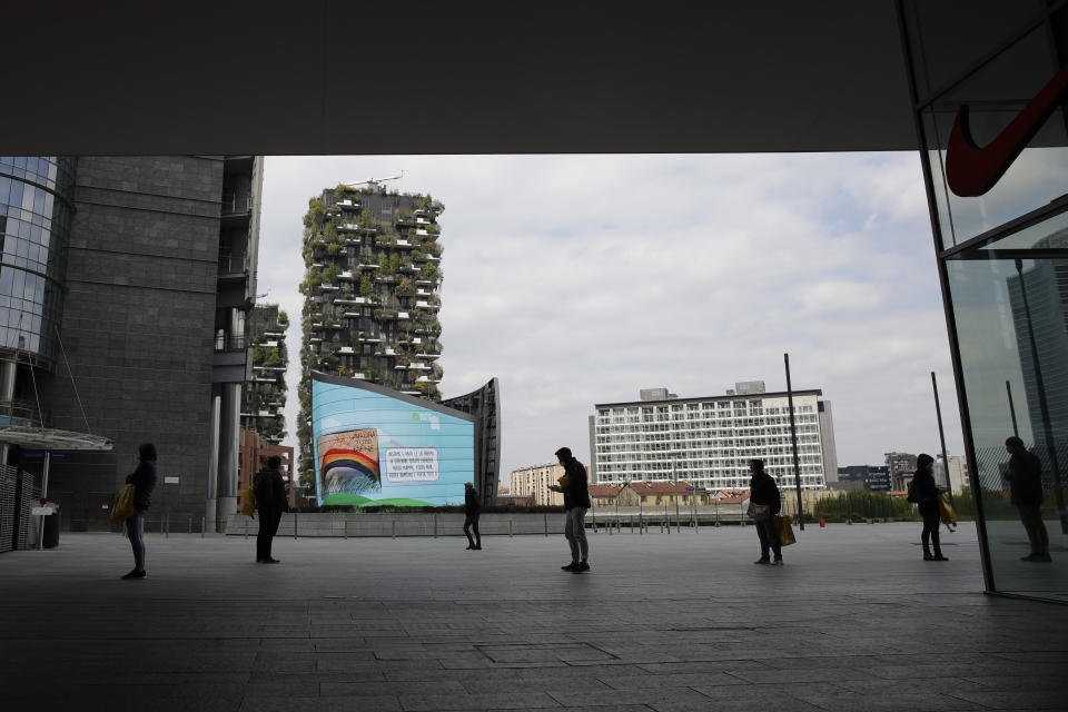 People line up outside a supermarket keeping the prescribed social distance, at the Porta Nuova business district in Milan, Italy, Wednesday, April 1, 2020. The new coronavirus causes mild or moderate symptoms for most people, but for some, especially older adults and people with existing health problems, it can cause more severe illness or death. (AP Photo/Luca Bruno)