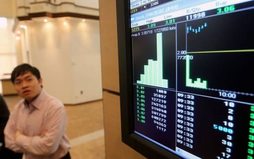 A man watches trading activity of IHH Healthcare Global shares on an electronic display shortly after the company's listing debut at Malaysia Stock Exchange in Kuala Lumpur on July 25, 2012. Fast-growing IHH employs 24,000 people in 30 hospitals and clinics in Malaysia, Singapore, Turkey, China and other Asian markets