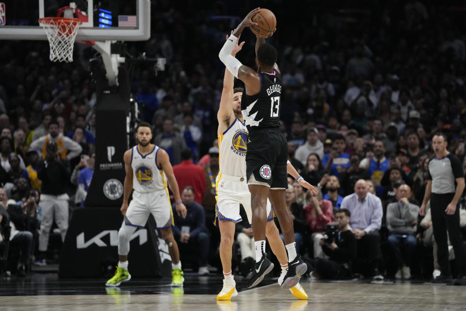 Los Angeles Clippers forward Paul George (13) shoots a 3-pointer against Golden State Warriors guard Klay Thompson during the second half of an NBA basketball game in Los Angeles, Saturday, Dec. 2, 2023. The Clippers won 113-112. (AP Photo/Ashley Landis)